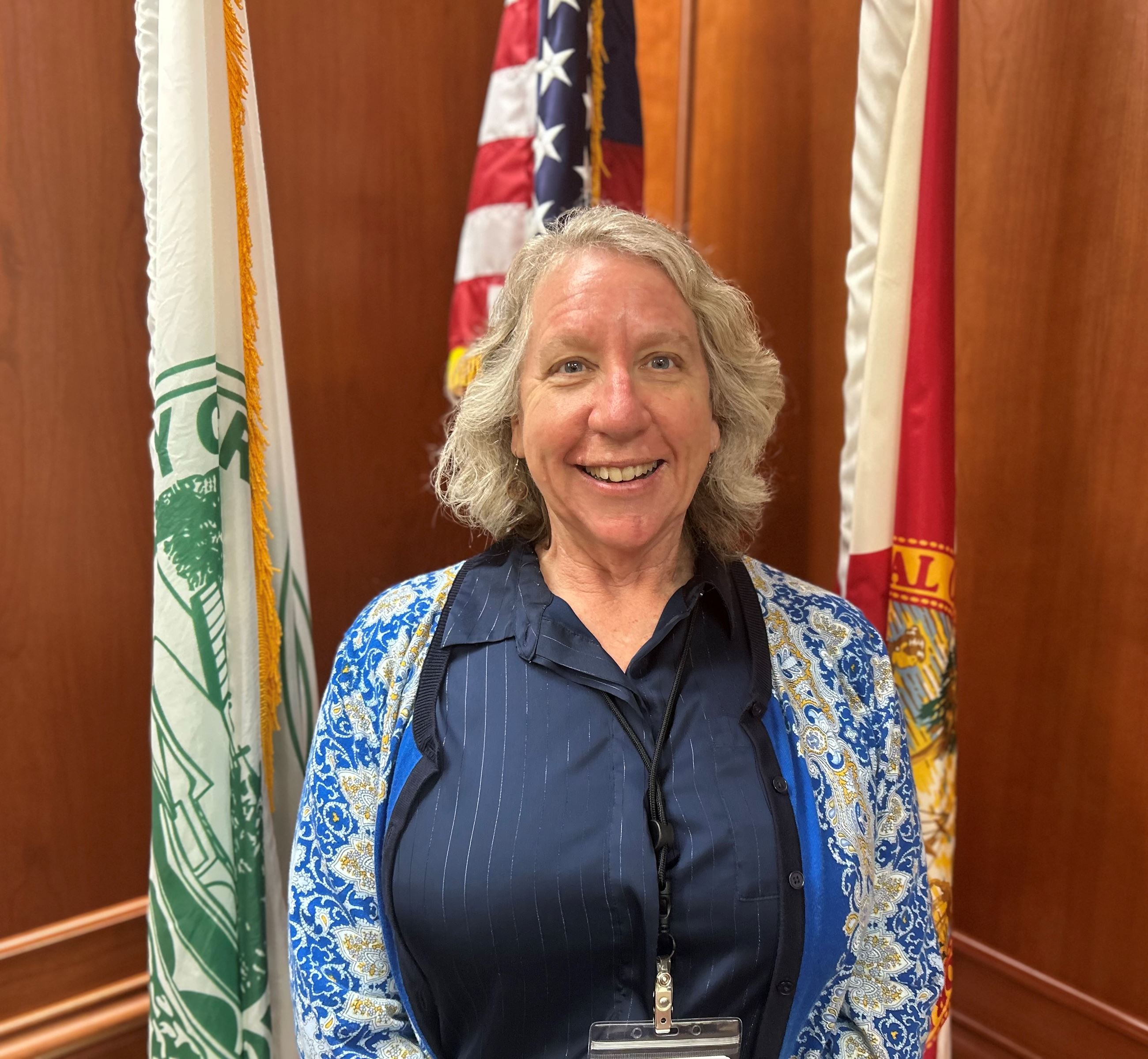 Lisa Walsh standing in front of American Flag in Council Chambers